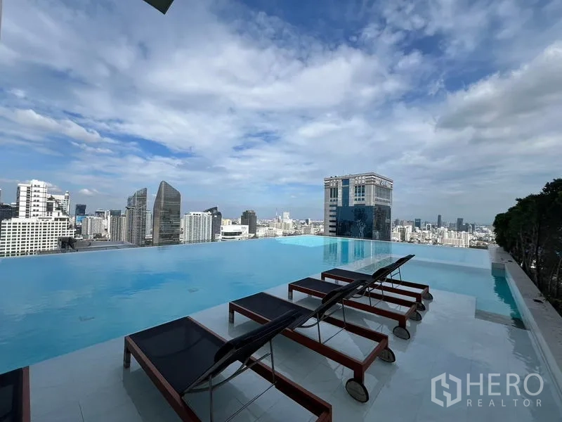 公寓 出租在Watthana, Bangkok - 屋顶无边际泳池，日光躺椅与阿索克天际线全景。