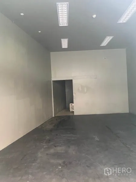 Retail Space for rent in Khlong Toei, Bangkok - Open-plan shop interior showing a rear service room and tall walls.