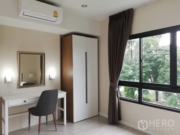 Townhouse for rent in Bang Kapi, Bangkok - Sunlit bedroom featuring a work desk, wardrobe, large windows and air conditioning.