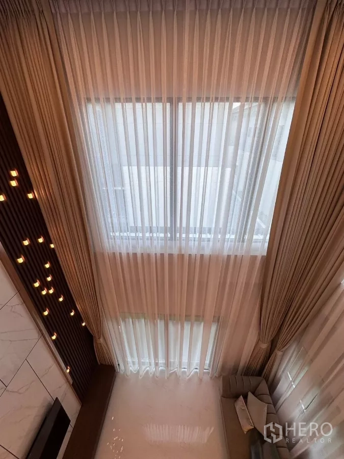 独立式住宅 出租在Bang Phli, Samut Prakan - 从楼上俯视高窗与纱帘，旁设装饰吊灯。