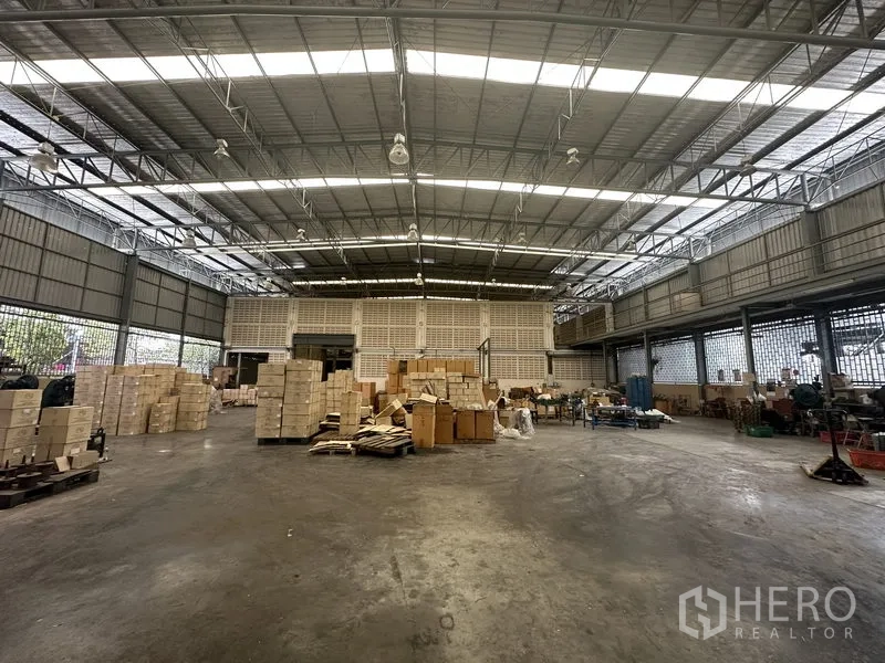 Factory for rent or sale in Lam Luk Ka, Pathum Thani - Warehouse storage area with stacked cartons and a loading zone.