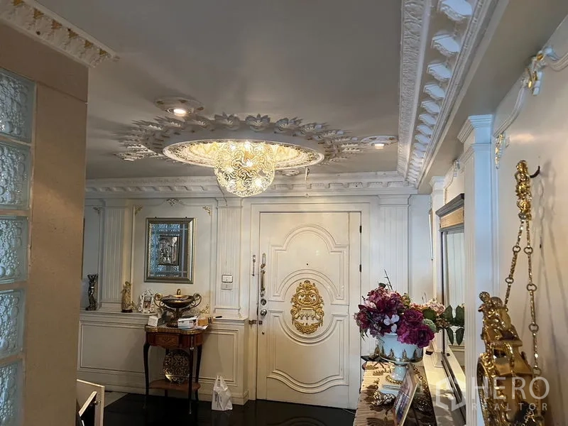 Condominium for sale in Khlong Toei, Bangkok - Grand foyer with embellished entrance door, floral ceiling medallion and console table.