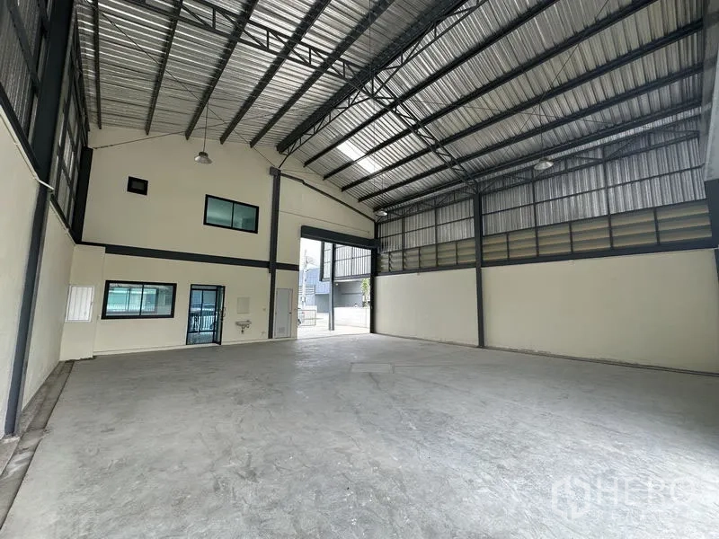 Factory for rent or sale in Bang Yai, Nonthaburi - Warehouse looking toward office block with windows, door and hand-wash sink.