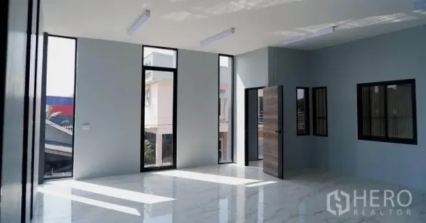 Warehouse for rent in Bueng Kum, Bangkok - Bright office room with floor-to-ceiling windows and glossy tile flooring inside the warehouse complex.