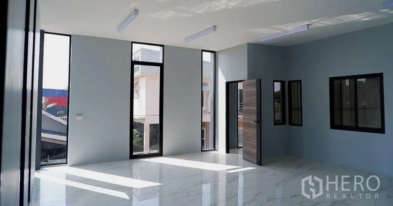 Warehouse for rent in Bueng Kum, Bangkok - Bright office room with floor-to-ceiling windows and glossy tile flooring inside the warehouse complex.
