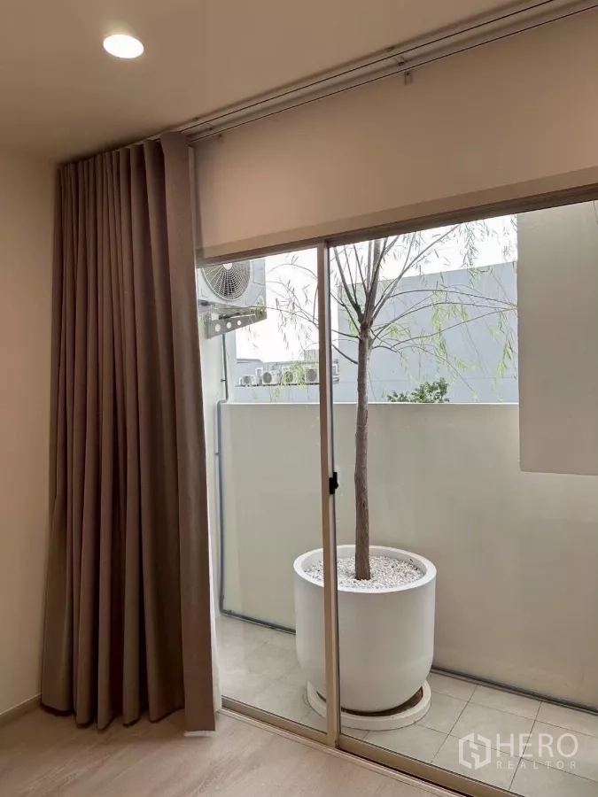 Townhouse for rent in Saphan Sung, Bangkok - Private balcony with sliding glass door and an oversized planter.