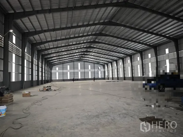 仓库 for rent or sale in Bang Phli, Samut Prakan - 仓库内部大跨空间，钢桁架屋顶与混凝土地面。