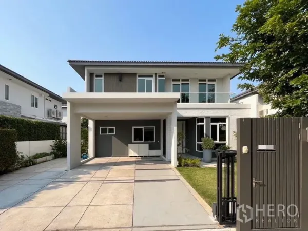 บ้าน ให้เช่าในSamut Prakan - บ้านเดี่ยวสองชั้นสมัยใหม่ ด้านหน้ามีโรงจอดรถ ทางเข้าประตูรั้ว และสนามหญ้า