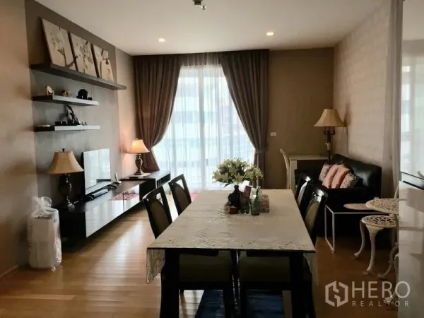 Condominium for rent in Watthana, Bangkok - Bright living-dining room with TV console, wall shelves, sofa and glass doors to the balcony.