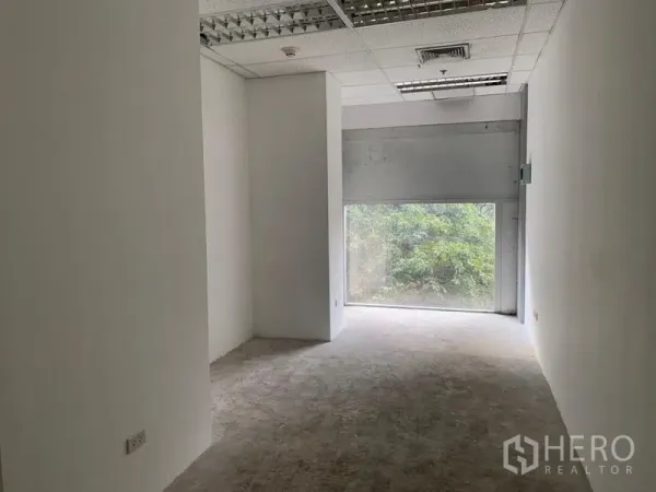 零售空间 出租 - 狭长型店铺空间，白墙、格栅吊顶，后窗引入自然采光与绿色景观