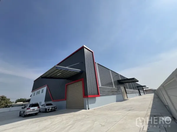 Warehouse for rent in Mueang Samut Prakan, Samut Prakan - Side elevation showing multiple roller shutter doors with canopies along a broad concrete apron for trucks.