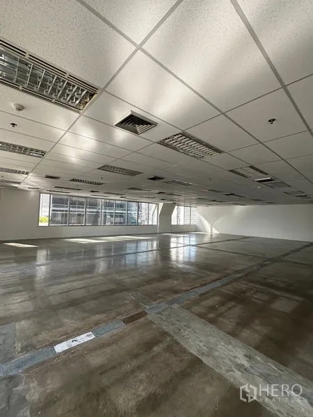 Office Space for rent in Pathum Wan, Bangkok - Expansive vacant office floor with drop ceiling lighting, polished flooring, and windows on two sides.