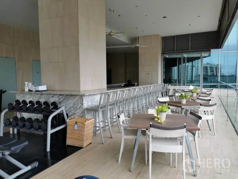 Condominium for rent in Pathum Wan, Bangkok - Fitness terrace with free weights, a long bar counter and outdoor dining tables.