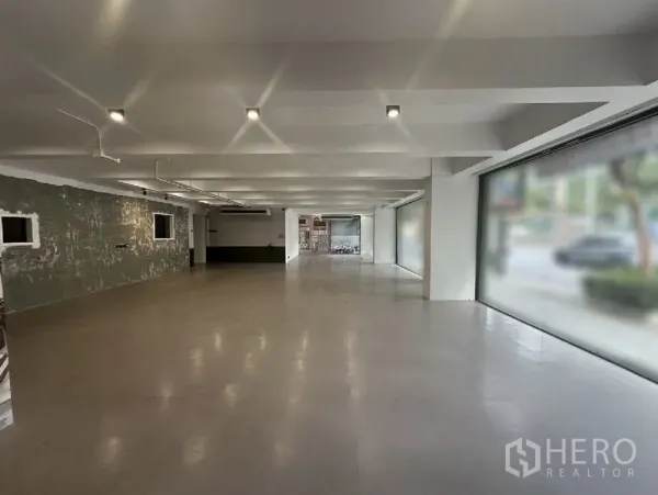 Retail Space for rent in Bang Rak, Bangkok - Long, flexible sales floor with multiple display windows on both sides and a textured feature wall.
