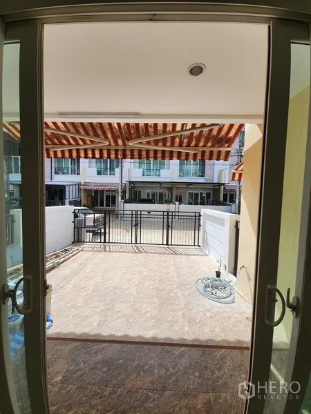 联排别墅 出租在Wang Thonglang, Bangkok - 从室内望向前庭与带篷车位的景象。