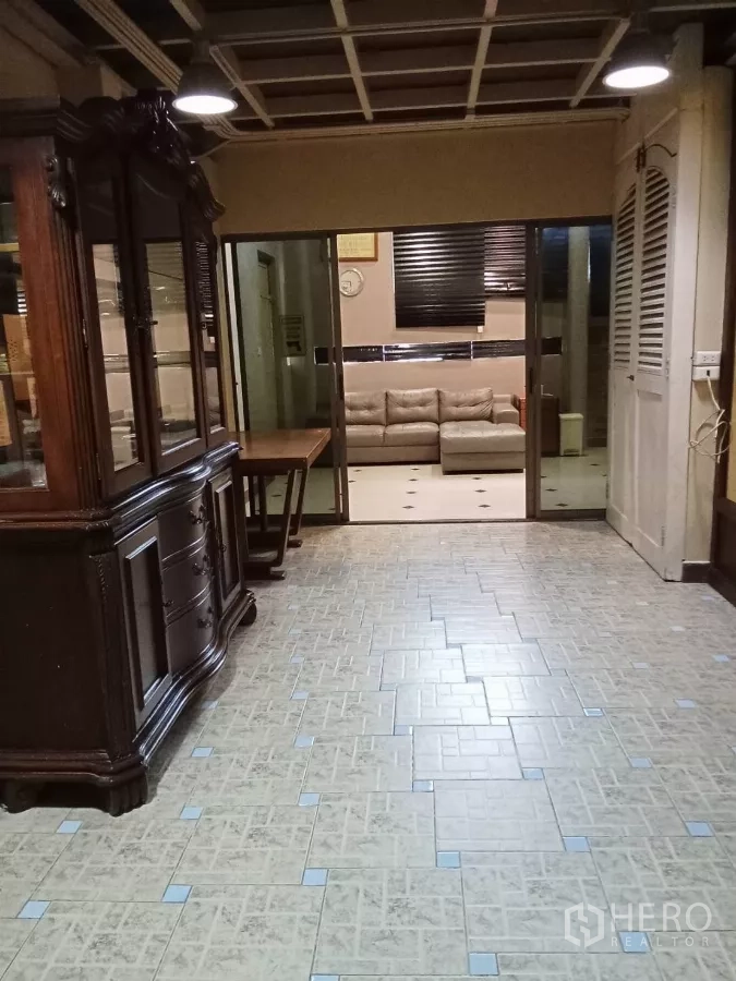 Home Office for rent in Lat Phrao, Bangkok - Hallway with vintage wooden cabinet looking into lounge through sliding glass