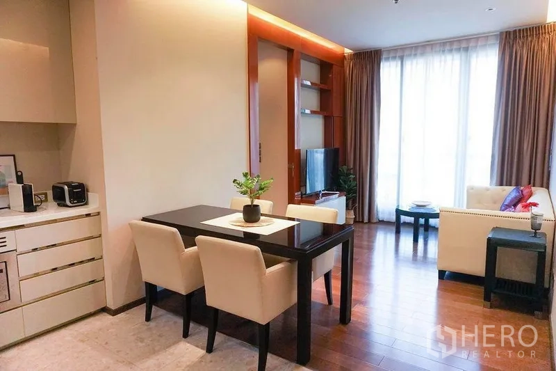 Condominium for rent in Khlong Toei, Bangkok - Open-plan dining and living area with four-seat table, TV and floor-to-ceiling windows near Phrom Phong.