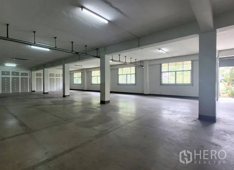 Factory for rent in Mueang Samut Prakan, Samut Prakan - Open hall with grid windows, ceiling lights and exposed service piping
