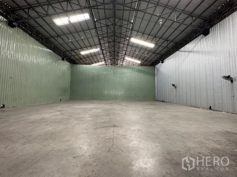 Warehouse for rent in Pak Kret, Nonthaburi - Spacious high-roof warehouse interior with steel trusses, bright LED lighting and durable concrete floor.