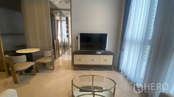 Condominium for rent - Living area with round dining nook, mirrored wardrobes and glass coffee table beside windows.