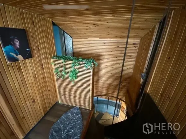 Condominium for rent or sale in Suan Luang, Bangkok - Wood-clad stair landing with greenery and a staircase leading to the lower floor.