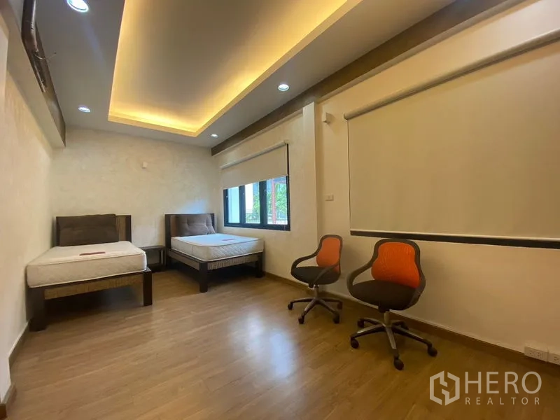 独立式住宅 出售在Khlong Toei, Bangkok - 次卧空间宽敞，双床、木地板与嵌灯。