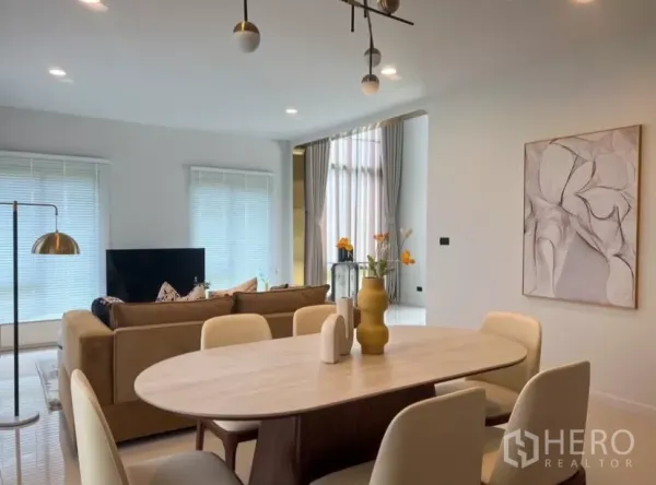 Detached House for rent or sale in Bang Kapi, Bangkok - Dining area with oval table and six chairs facing the living room under a contemporary pendant light.