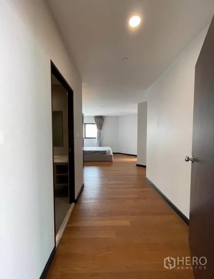 Condominium for rent in Sathon, Bangkok - Wide hallway with wooden floors connecting to bedroom and bathroom.
