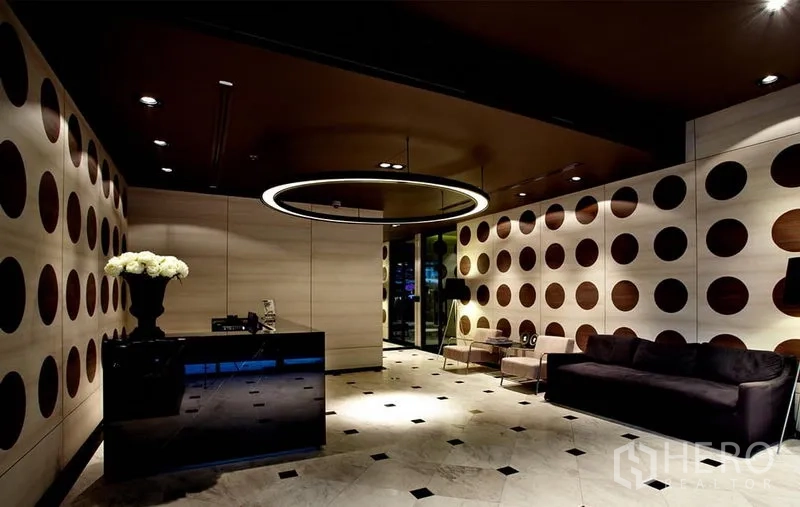 Condominium for rent or sale in Phaya Thai, Bangkok - Stylish lobby with circular ceiling light, patterned walls and sofa seating.