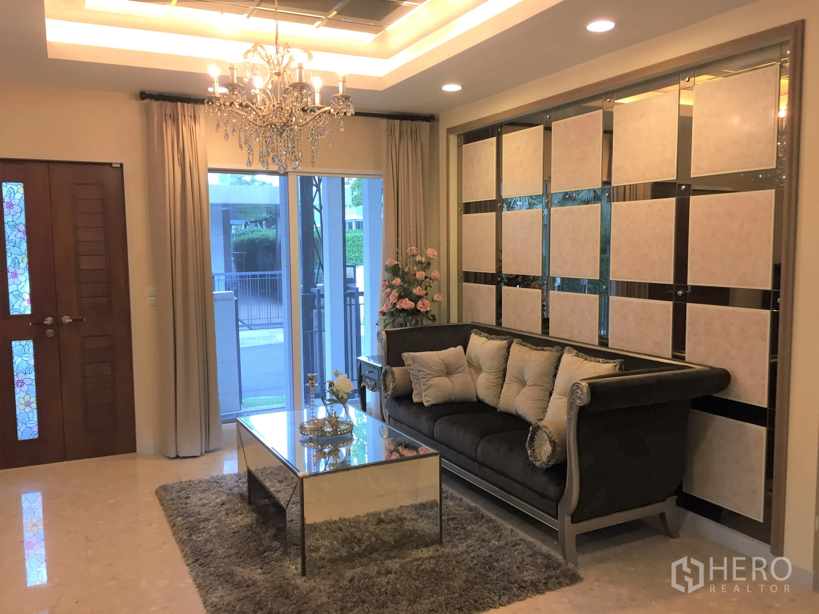 Detached House for sale in Saphan Sung, Bangkok - Formal living area with crystal chandelier, mirrored feature wall and plush classic sofa.