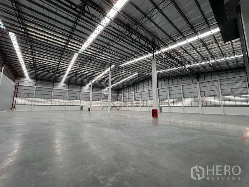Warehouse for rent in Bang Phli, Samut Prakan - Spacious warehouse interior with high clear-span steel roof and polished concrete floor.