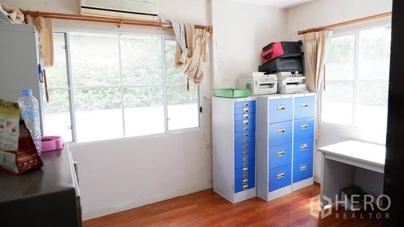 独立式住宅 出租在Prawet, Bangkok - 采光充足的书房，带文件柜、书桌与木地板。