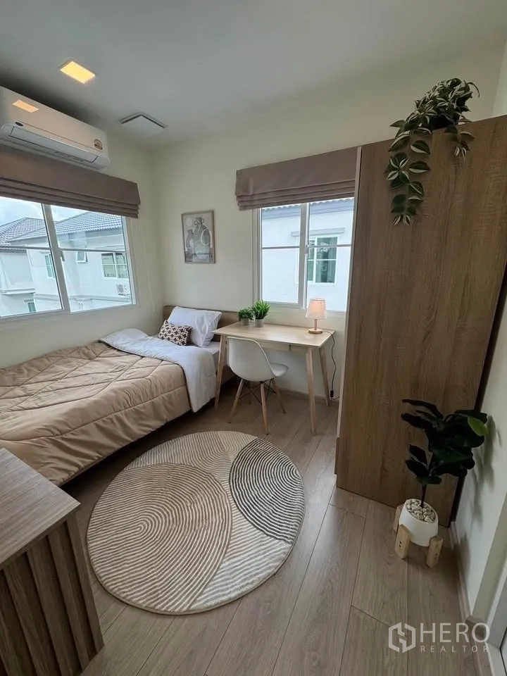 Detached House for rent in Bang Phli, Samut Prakan - Bright single bedroom with a study desk, wardrobe, and two windows.