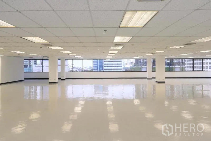 Office Space for rent in Bang Rak, Bangkok - Expansive open-plan office floor with grid ceiling lights and a wall of windows with city views
