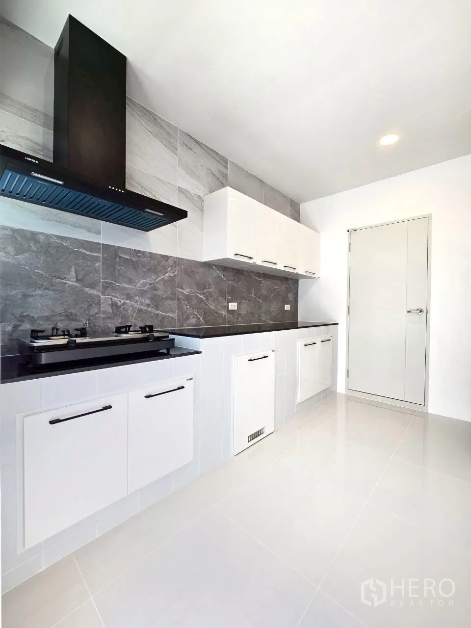 Detached House for rent in Bang Phli, Samut Prakan - Sleek kitchen with gas hob, hood and white cabinetry