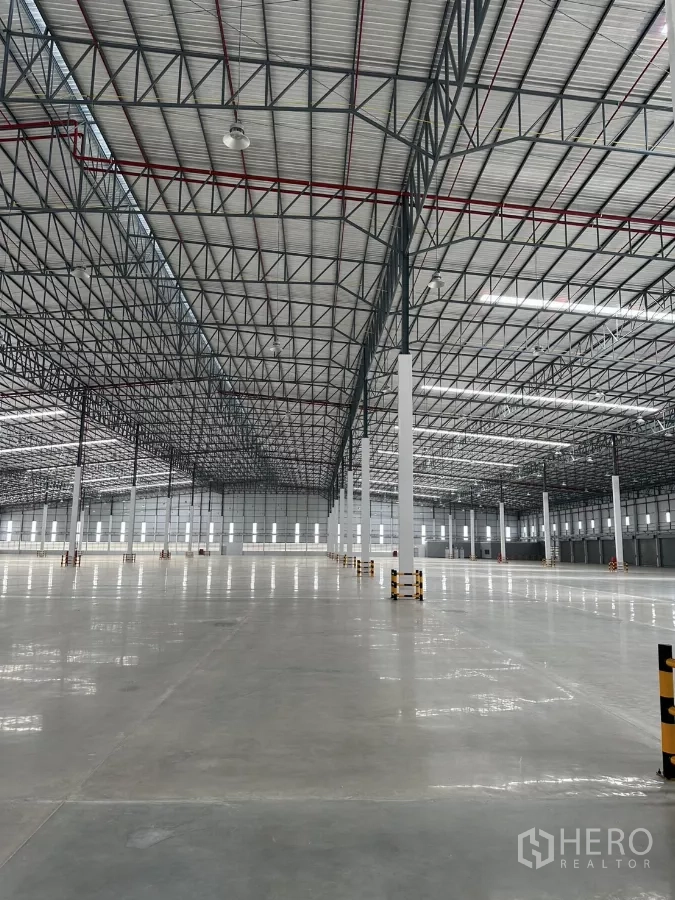 工厂 出租在Chon Buri - 大跨度仓库大厅，光亮混凝土地面与侧窗采光。