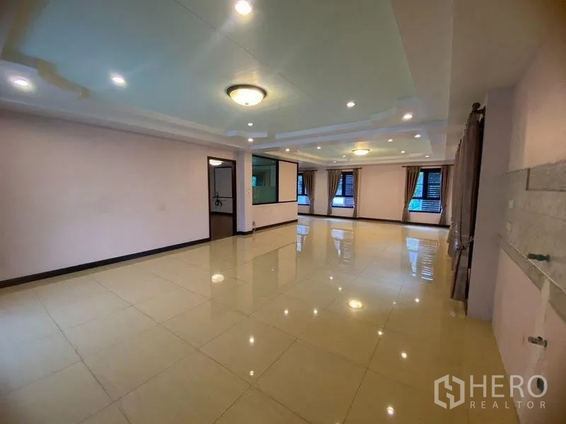 Home Office for rent in Don Mueang, Bangkok - Open-plan hall with large windows, curtains and a partition wall.