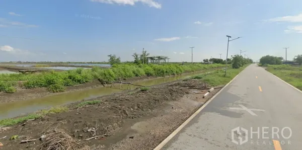 Land for sale in Mueang Samut Sakhon, Samut Sakhon - Local canal-side access road with streetlights beside green embankments and water channels.