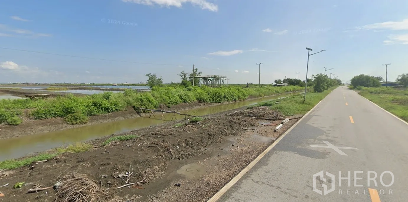 Land for sale in Mueang Samut Sakhon, Samut Sakhon - Local canal-side access road with streetlights beside green embankments and water channels.