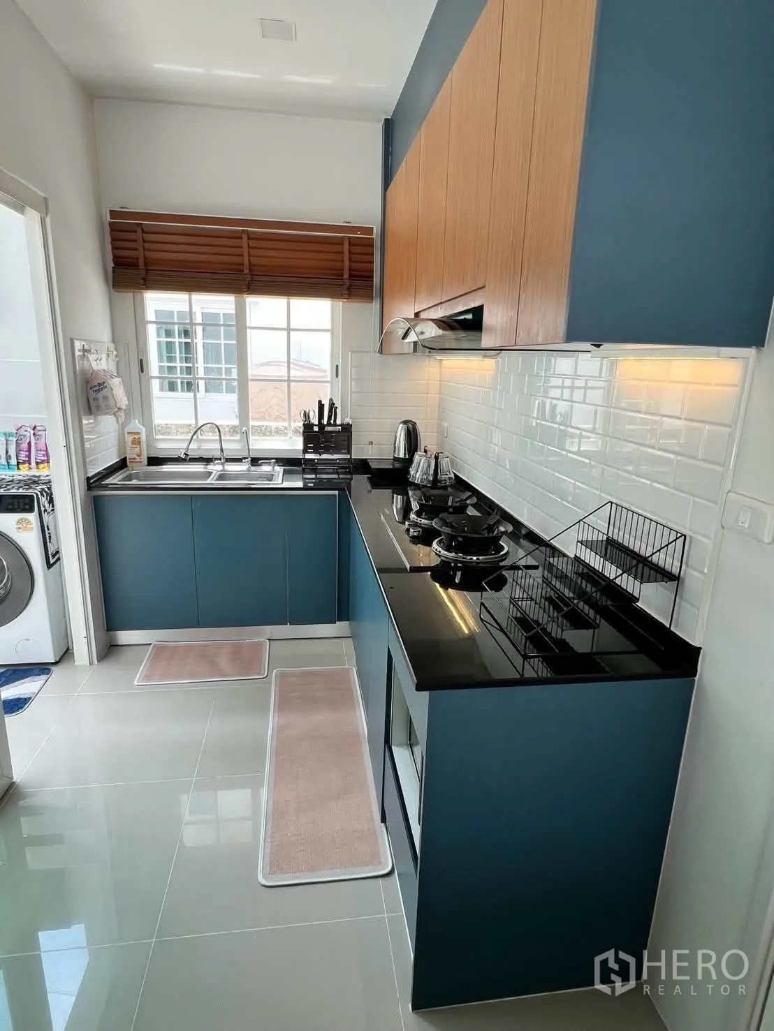 半独立式住宅 for rent in Prawet, Bangkok - 明亮厨房，蓝色橱柜、黑色台面与燃气灶