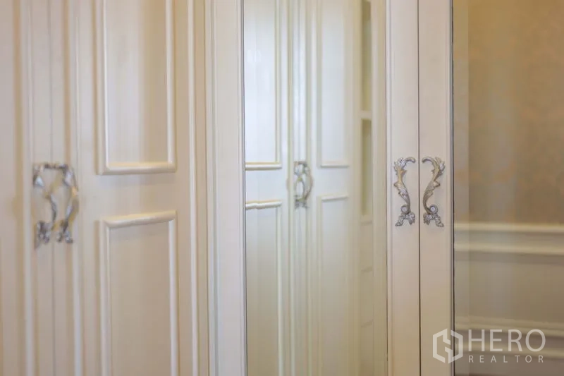 Condominium for rent in Khlong Toei, Bangkok - Built-in wardrobes with mirrored doors and ornate silver handles.