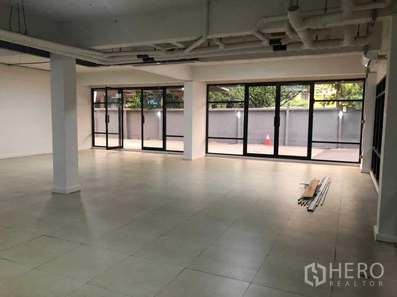 Office Space for rent in Phaya Thai, Bangkok - Corner workspace with wraparound glass and outdoor views onto a private forecourt.