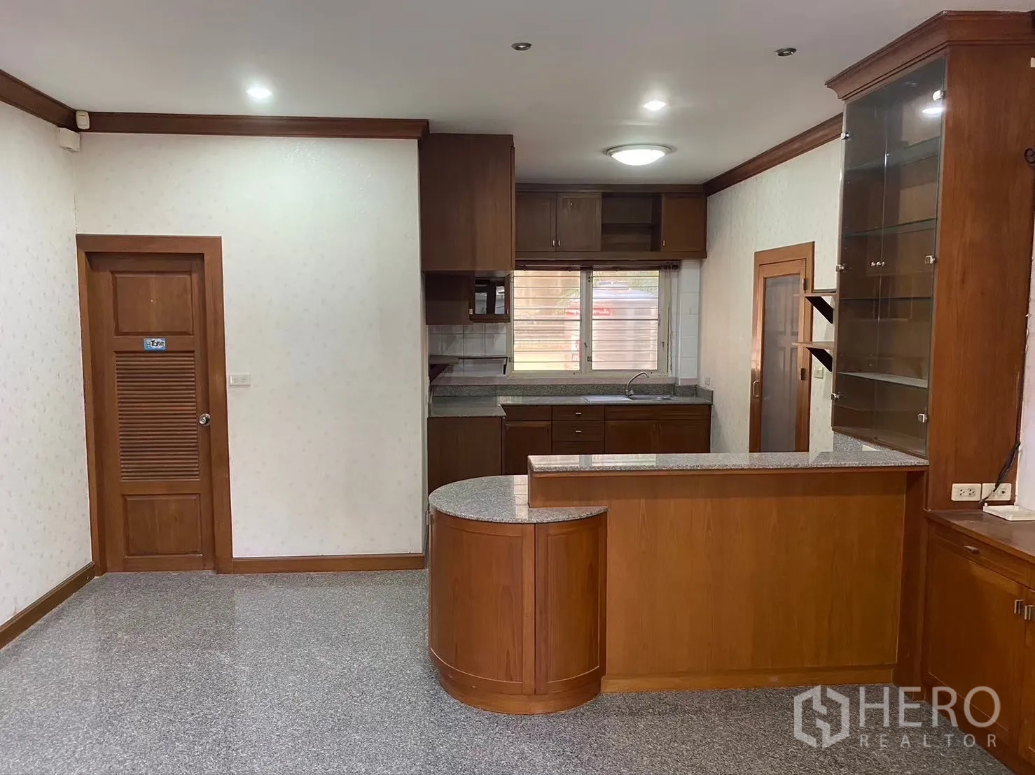 Detached House for rent in Watthana, Bangkok - Kitchen zone with granite counters and glass cabinet display.