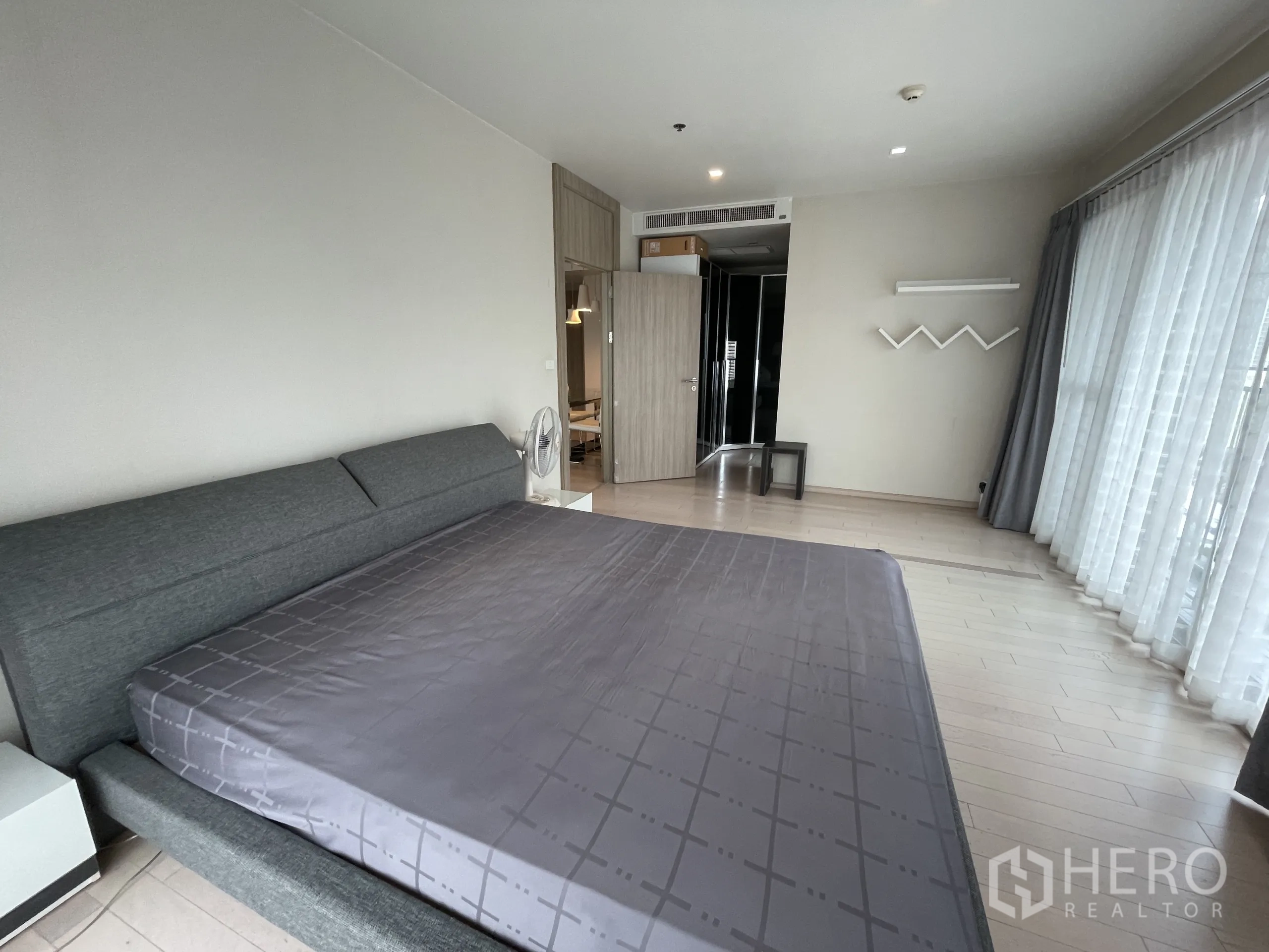 คอนโด ให้เช่าในWatthana, Bangkok - ห้องนอนกว้าง เตียงคิงส์ไซส์ พื้นไม้โทนอ่อน และหน้าต่างรอบด้านพร้อมม่านโปร่ง