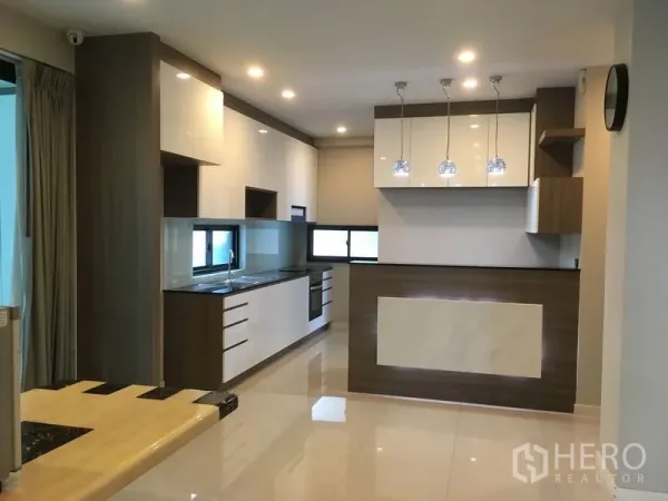 Detached House for rent or sale in Bang Kapi, Bangkok - Modern fitted kitchen with glossy cabinets, island bar and pendant lights.