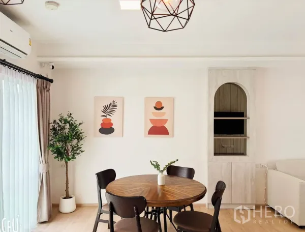 Townhouse for rent in Bang Phli, Samut Prakan - Round dining table set near glass doors with wall art and indoor plant.