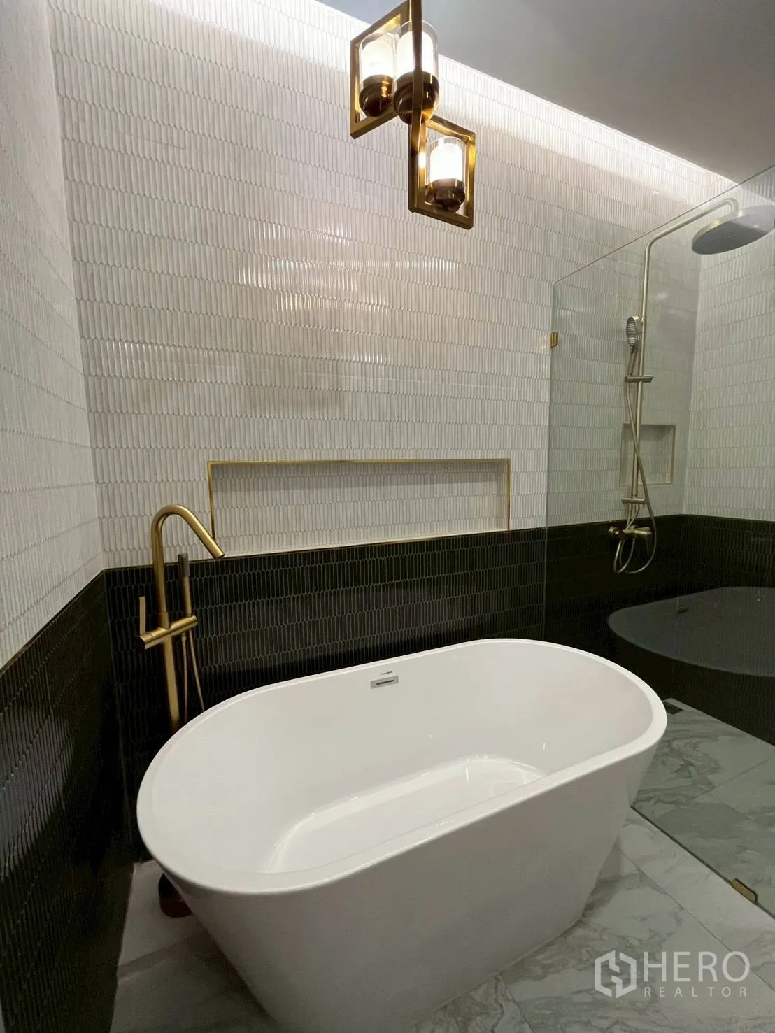 联排别墅 for rent in Khlong Toei, Bangkok - 现代浴室，设独立浴缸、金色龙头、玻璃淋浴与纹理墙砖。