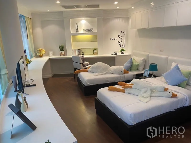 Apartment for rent in Watthana, Bangkok - Close-up of the twin bedroom showing built-in shelving and two single beds.