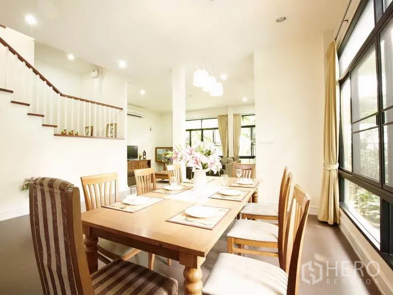 Detached House for rent in Khlong Toei, Bangkok - Bright open-plan dining area with wooden table and staircase