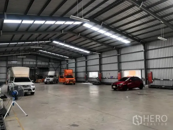 货栈 出租在Don Mueang, Bangkok - 仓库分区，车辆停放在采光板与LED灯下。